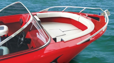 Bow of a bright red bowrider, complete with cushions and backrests