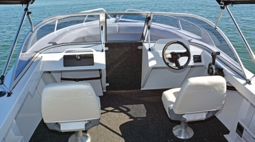 Bow of white Formosa bowrider, showing passenger and driver seats aswell as steering and glovebox