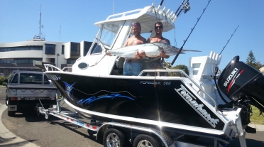 Two happy customers on their Formosa Tomahawk 580 Centre Console Fixed Visor Hard Top with a caught Marlin