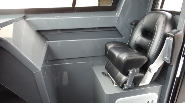 Drivers seat, console and side storage pocket in a half cabin boat
